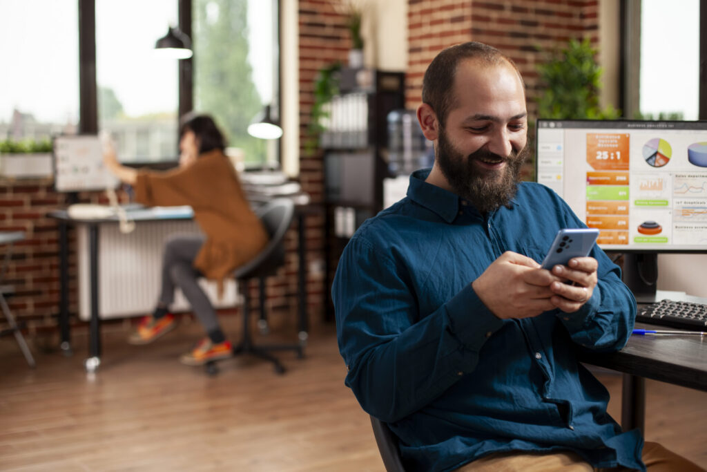 Man texts on cellphone in startup office
