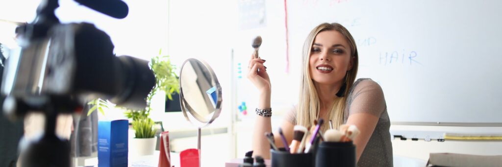 Beautiful woman blogger shows how to apply makeup and use cosmetics